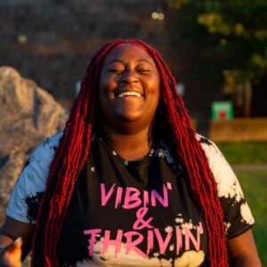 Youth smiling widely with a shirt reading "VIBIN' & THRIVIN'"
